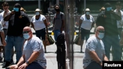 Эти американцы продолжают носить маски, чтобы не допустить распространения COVID-19. Штамм "Дельта" привел к росту числа инфицированных в Нью-Йорке, 30 июля 2021 года