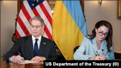Міністр фінансів США Скотт Бессент і перша віцепрем’єр-міністерка, міністерка економіки України Юлія Свириденко підписують угоду про мінерали. 1 травня 2025 року.