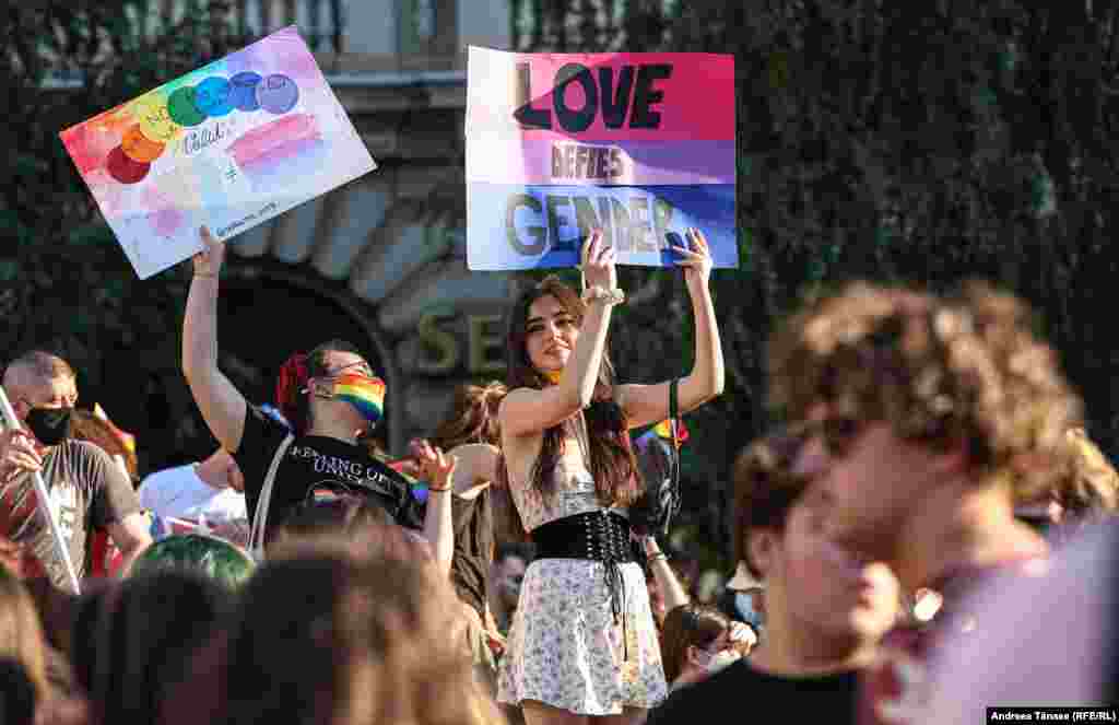 Tinere purtând pancarte participă la marșul Bucharest Pride.
