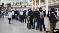 Passengers wait in line for new plane tickets at Copenhagen Airport on September 23, a day after unidentified drones disrupted flights at the aviation hub. 