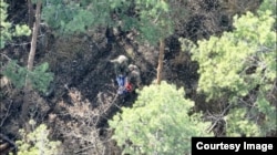 Bruce și un alt luptător, cu un steag rus găsit după ce au capturat o poziție lângă Liman, în regiunea Donețk din Ucraina.