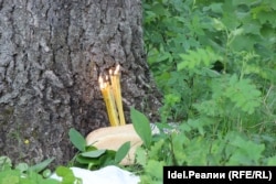 Candles burn in a loaf of bread left as an offering during the ceremony.
