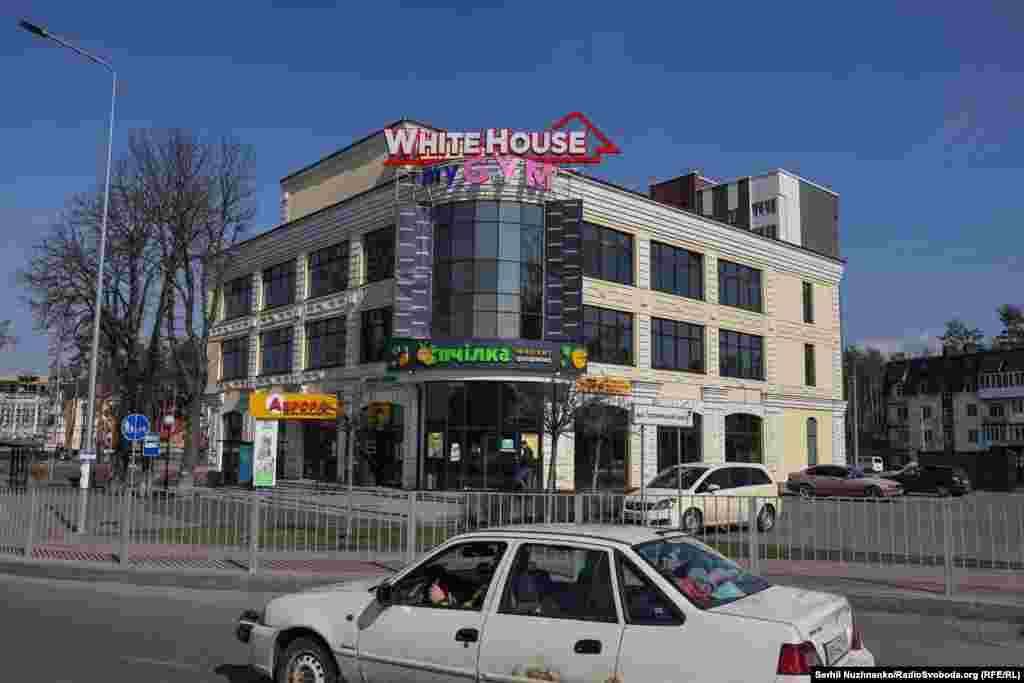 Пошкоджений обстрілами торговий центр на Гостомельському шосе. Зараз цю будівлю відновили. Житлові багатоповерхівки позаду, які було пошкоджено внаслідок обстрілів – демонтували.Ліворуч фото від 7 квітня 2022, праворуч – березень 2025 року