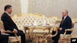 Președinții rus și chinez, Vladimir Putin și Xi Jinping, la un ceai la Kremlin pe 8 mai, înainte de parada de Ziua Victoriei, fiecare având în față propriul său ceainic.