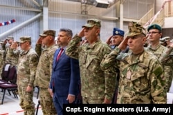 Бригадний генерал армії США віддає честь разом з урядовцями та генералами Збройних сил Румунії на авіабазі Міхаїла Когелнічану, Румунія, 27 жовтня 2025 року