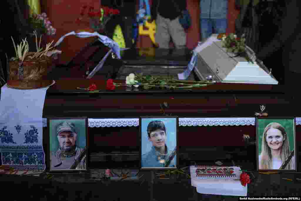 Портрети загиблої родини біля домовин 