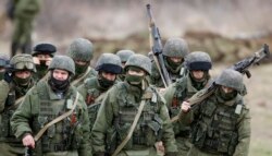 Российские военнослужащие в форме без опознавательных знаков маршируют возле украинской военной части в Перевальном, 5 марта 2014 года