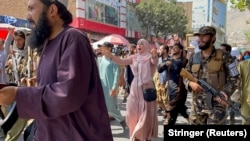 آرشیف، حضور شماری از جنگجویان طالبان میان اعتراض کننده‌گان زن و مرد در شهر کابل، بیشتر این‌گونه اعتراض‌ها از سوی طالبان سرکوب شده و حتی برای پراگنده کردن معترضان تیراندازی کرده‌اند.