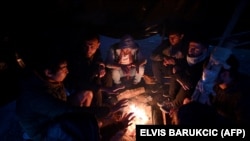 Izbjeglice iz Avganistana okupljene oko vatre griju se u blizini Velike Kladuše u BiH, blizu granice sa Hrvatskom, 15. oktobar 2021. 