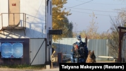 Un gardian de închisoare cu un câine este văzut lângă o intrare în unitatea de corecție pentru bărbați IK-2, unde își execută pedeapsa liderul opoziției ruse Alexei Navalnîi, în orașul Pokrov, Rusia, 8 octombrie 2021.