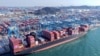 Macarale descarcă containere de pe o navă într-un port din Qingdao, în provincia Shandong din estul Chinei, aprilie 2025.