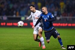 Mbrojtësi i Zvicrës, Ricardo Rodriguez (majtas), lufton për topin me sulmuesin e Kosovës, Edon Zhegrova, gjatë ndeshjes kualifikuese të Grupit B për Kupën e Botës 2026 midis Kosovës dhe Zvicrës, në Prishtinë.