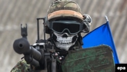 Militar ucrainean cu cuvintele 'War is Hell' scrise pe cască, în regiunea Donețk. 