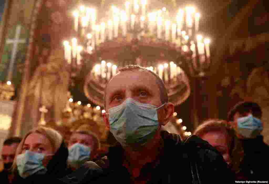 Credincioși purtând măști de protecție în timpul Liturghiei de Crăciun de la Catedrala Sf. Volodymyr din Kiev.