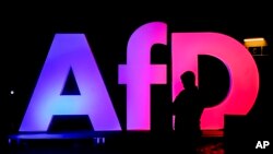 Un bărbat stând în fața biroului central al AfD din Berlin 