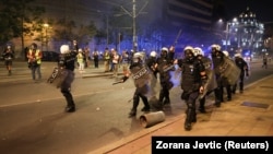 Iskustva sa terena pokazuju da su uslovi u kojima reporteri rade u Srbiji u poslednje vreme ekstremno nebezbedni. Na fotografiji: novinari sa šlemovima i gas maskama iza policajaca na protestu u Beogradu, Srbija, 15. avgust 2025.