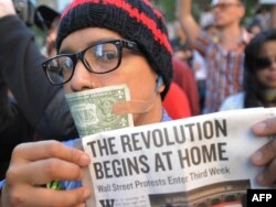 A man with a U.S. dollar bill taped over his mouth joins Occupy Wall Street protesters during a march to Foley Square in New York.