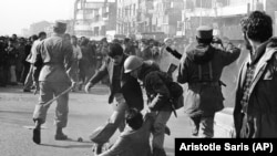 ჯარისკაცი ცდილობს წამოაყენოს დემონსტრანტი, რომელიც შეხლა-შემოხლის დროს არმიის ოფიცერმა სცემა ჯოხით. 1979 წლის 14 იანვარი.