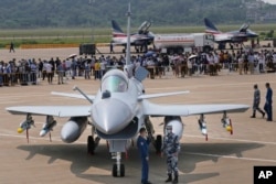 Chinese military personnel stand near a J-10C fighter jet during the 13th China International Aviation and Aerospace Exhibition, also known as Airshow China, in September 2021.