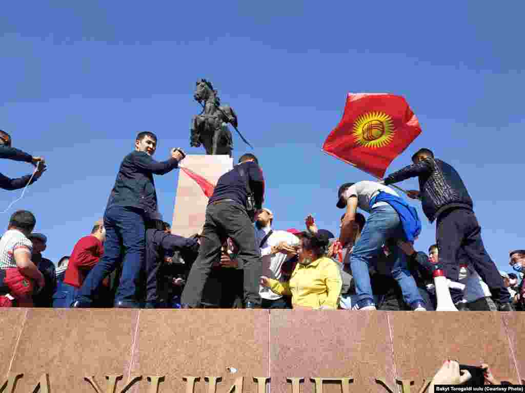 Бишкектин Ала-Тоо аянтында шайлоонун жыйынтыгын жокко чыгарууну талап кылып жаткан митингде кайрадан чуу чыкты. Трибунада "Мекен ынтымагы" партиясынын лидери Темирбек Асанбеков сүйлөп жатканда "Чоң казат" партиясынын өкүлү Сыймык Жапыкеев микрофонду тартып алууга аракет кылды. Ортодо кайым айтышуу чыгып, ага сөз берилген жок. 