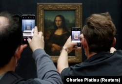 ვიზიტორები უღებენ ფოტოს ლეონარდო და ვინჩის ნახატს "მონა ლიზა" პარიზის ლუვრის მუზეუმში. 2020 წლის 6 ივლისი