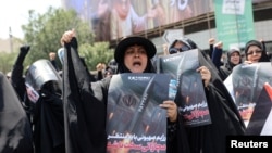 People attend an anti-Israeli protest in Tehran carrying portraits of generals and nuclear scientists killed in the Israeli strikes on Iran on June 13, 2025.