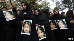 Afghan people carry photos of killed victims and shout slogans against the killing of civilians from Hazara minority, who were allegedly slain by the Islamic State (IS) militants in Zabul, during a protest in Herat, on November 12.