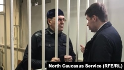 Oyub Titiyev (left) in the defendant's cage in a Chechen court on March 11