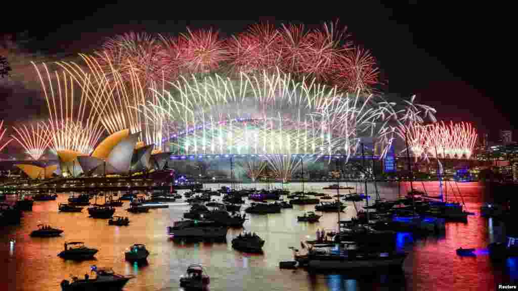 Фейерверк над Сиднейским оперным театром и мостом Харбор-Бридж во время празднования Нового года в Сиднее, Австралия.