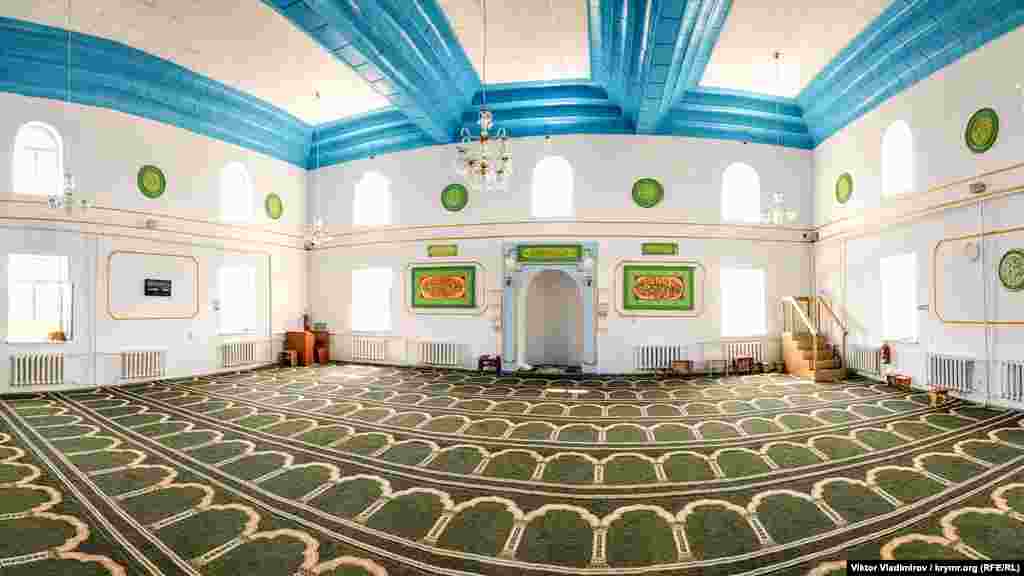 Головний зал мечеті, де проводяться колективні намази (молитви). В очі впадає поєднання різних кольорів, дерев'яне оформлення на стелі і сури зі священної книги Коран на стінах