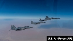 Американський бомбардувальник В-52 (праворуч) летить із F-15 ВПС Саудівської Аравії під час місії на Близькому Сході, 27 січня 2021 року