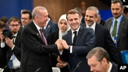 Președintele turc Recep Tayyip Erdogan (stânga) dă mâna cu președintele francez Emmanuel Macron la o sesiune plenară în timpul summitului Comunității Politice Europene (CPE) de la Budapesta, în noiembrie 2024.