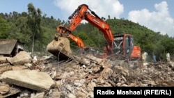 Recovery crews hunt for bodies among the ruins of a building in the village of Bishonai in Pakistan's Buner district on August 19 after floods swept through the region. 