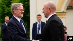 Прем’єр-міністр ЧехіїПетр Фіала (ліворуч) вітає свого українського колегу Дениса Шмигаля під час зустрічі для обговорення співпраці у сфері безпеки у Празі, Чехія, 28 травня 2024 року