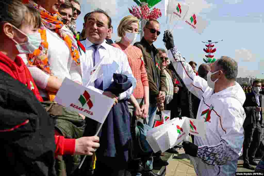 Мужчына раздае сьцяжкі рэспубліканскага грамадзкага аб'яднаньня &laquo;Белая Русь&raquo;