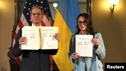 Iulia Sviridenko și ministrul american de Finanțe, Scott Bessent, prezentând camerelor de luat vederi acordul privind mineralele rare semnat de ei la Washington, pe 30 aprilie 2025