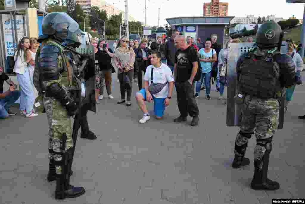 Security forces in riot gear stand near the site where a protester died in Minsk.