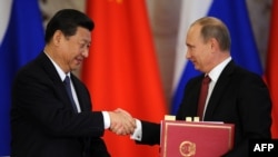 Russian President Vladimir Putin (right) shakes hands with his Chinese counterpart, Xi Jinping, during a document-signing ceremony in Moscow in March.