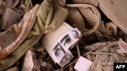 Pictures of people's eyes lie amid the rubble of a residential building that was hit in an Israeli strike, in Tehran