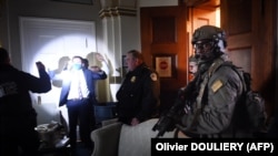 АКШ Конгрессинин кызматкерлери кол көтөрүп турушат. Полициянын атайын кошууну кол салгандарды иликтөөдө.  Капитолий, Вашингтон. 2021-жылдын 6-январынын кечи.