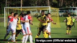 Оюнчулар стадиондо бири бирине муштум кезеген кез. "Алай" сары-кара, "Алга" ак-кызыл кийимчен.
