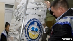 Members of a local election commission empty a ballot box at the end of the voting day on October 10.