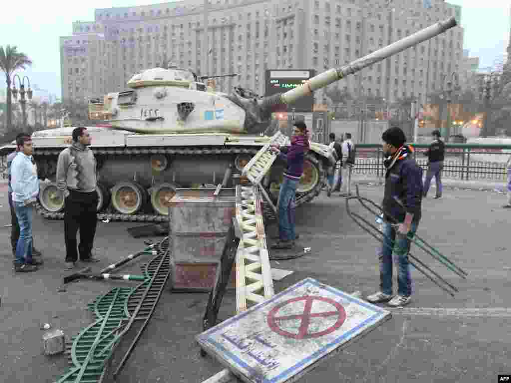 A man builds a barricade in front of a tank in central Cairo on January 29. 