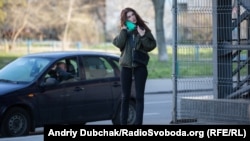 Аліса вдягає маску перед тим, як увійти до супермаркету біля метро Героїв Дніпра