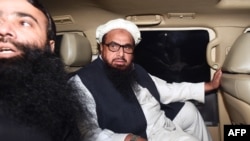 FILE: Hafiz Saeed, leader of the Jamaat-ud-Dawa (JuD) organisation Hafiz Saeed (R) leaves in a car after being detained by the police in the eastern city of Lahore in January.
