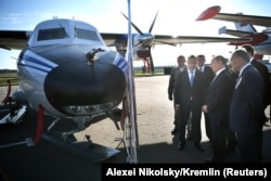 Путин вместе со своими чиновниками осматривает самолет L-410, участвовавший в российских военных учениях, 19 сентября 2018 года.
