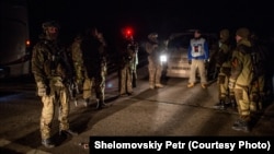 Представник ОБСЄ посередині між українськими військовими і бойовиками на місці обміну полоненими