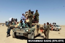 A group of Taliban militants poses for photographs with Afghan Army soldiers during the recent cease-fire.