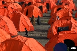 Afghan refugee women walk through tents after arriving from Pakistan at a makeshift camp near the Afghanistan-Pakistan Torkham border crossing in Nangarhar Province on April 20.