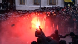 Protesters clash with riot policemen outside the Ukrainian President's office in Kyiv.